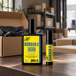 Durden 2 spray cologne and roll-on on a packing table beside an open shipping box